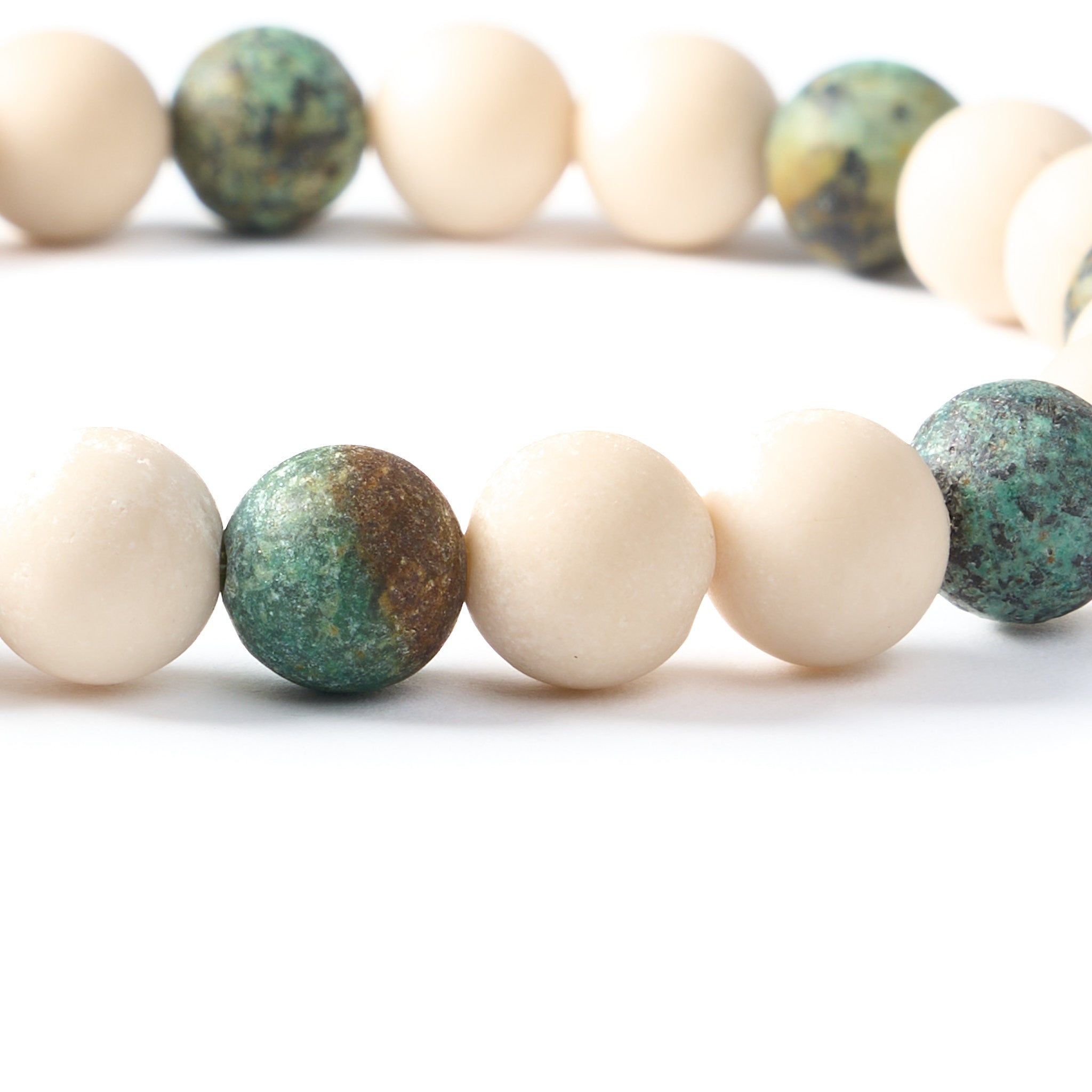 Detailaufnahme Armband The Earth’s Memory mit gemustertem afrikanischen Türkis und cremefarbenem Flussstein.