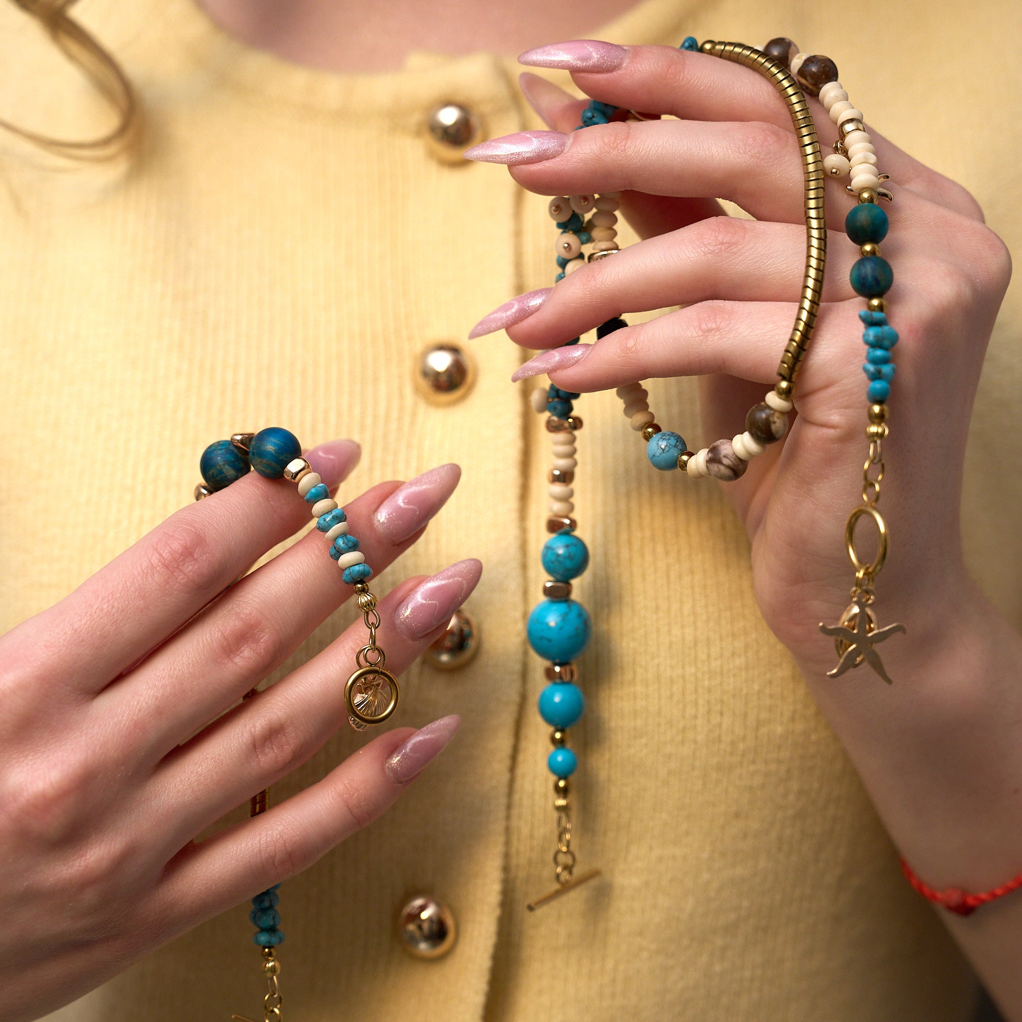 Detail Schmuckset Türkis: Perlenmix aus Türkis, blauem Tigerauge, Muschel, Bilderjaspis, Howlit und Hämatit mit goldfarbenen Meeresanhängern